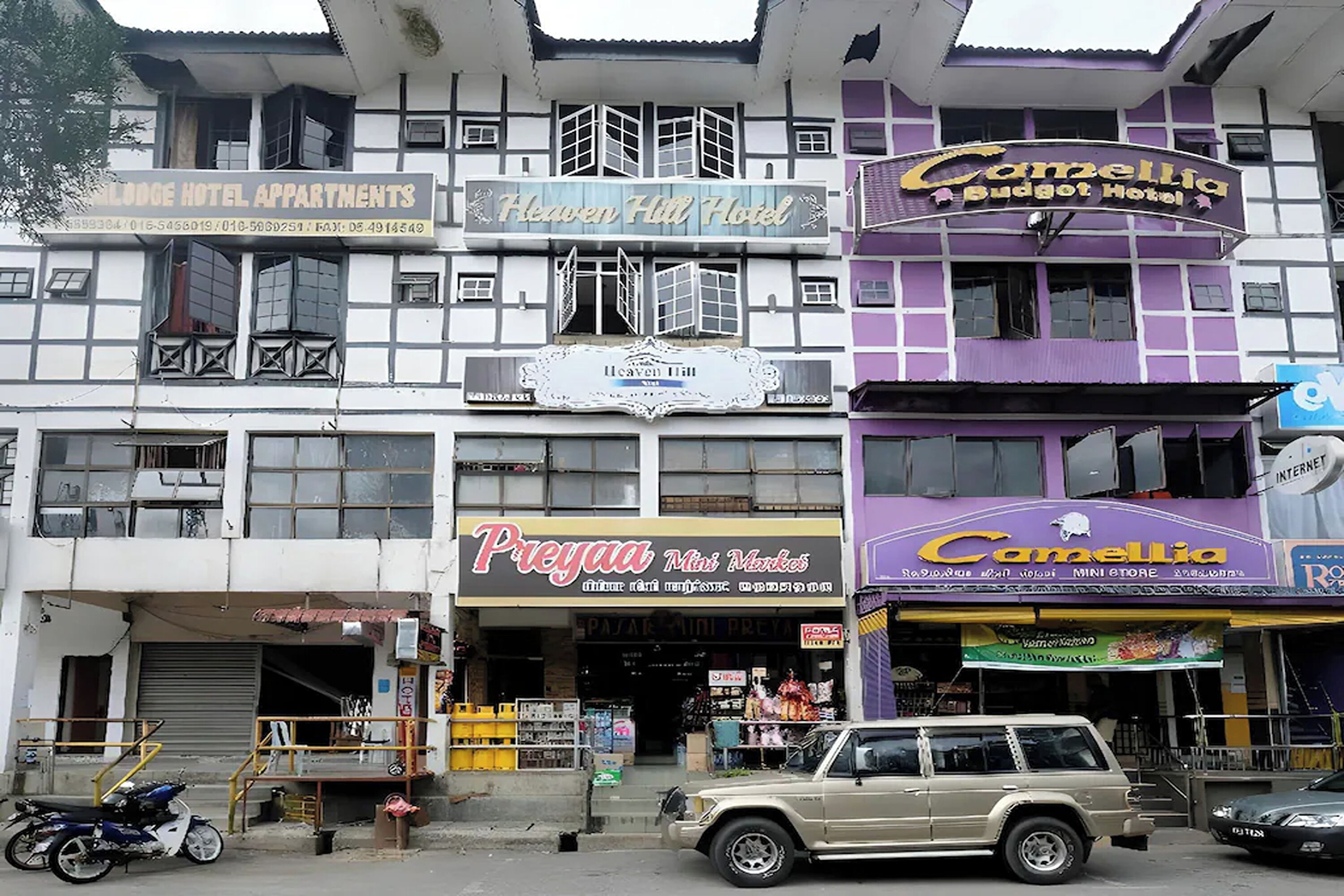 A multi-story building with various businesses including a hotel, mini market, and budget hotel.