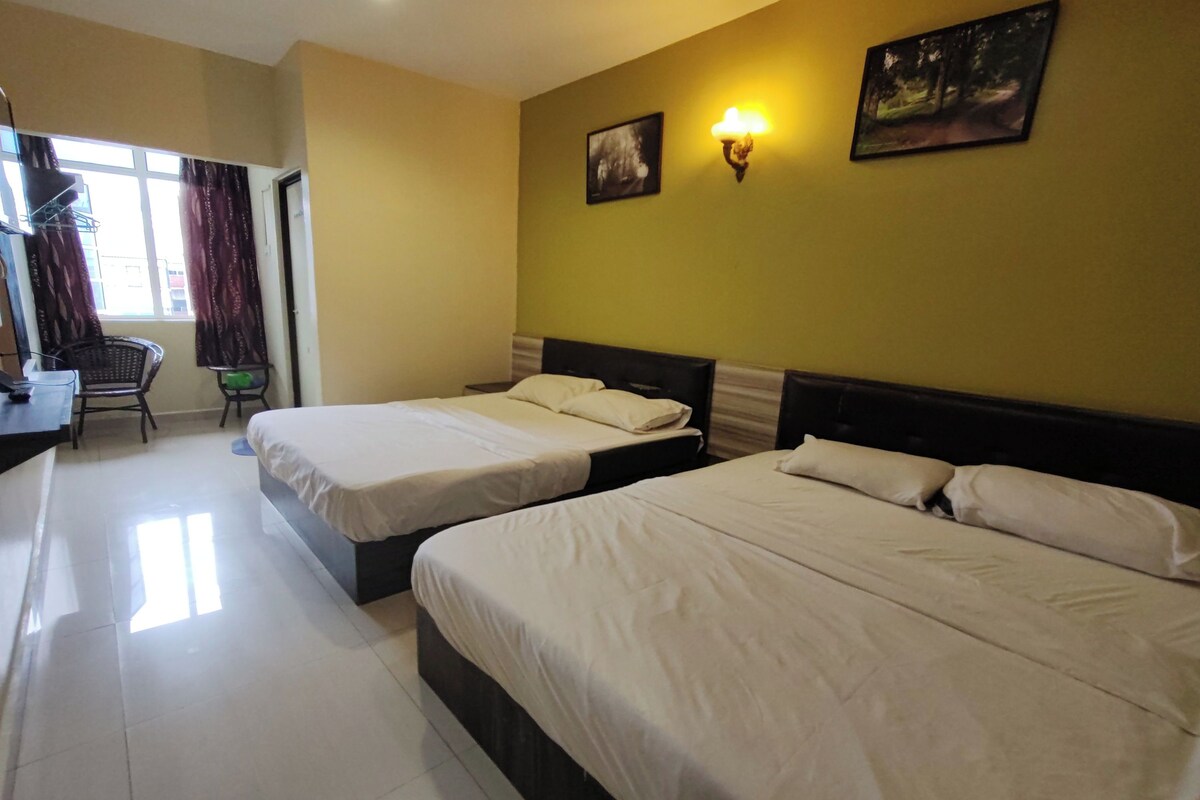 A hotel room with two beds, a desk, a chair, and a window with curtains.