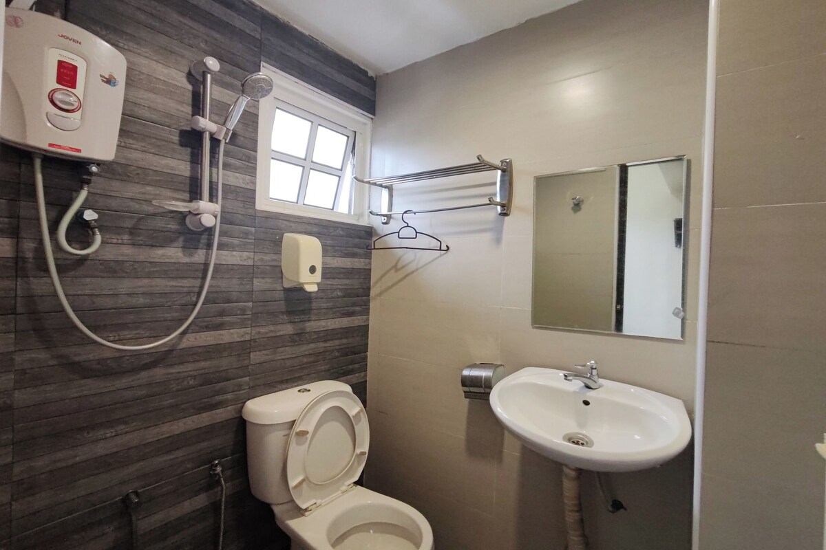 A bathroom with a toilet, a shower, a sink, and a towel rack.