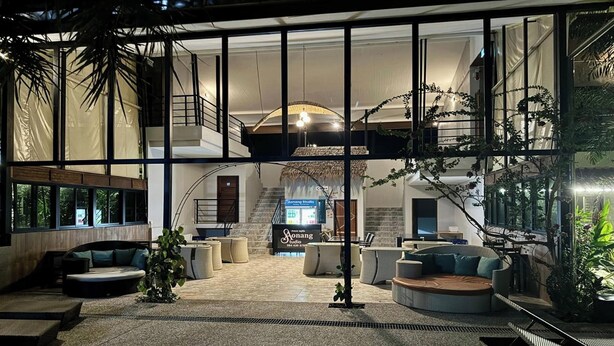 A spacious lobby with a high ceiling, large windows, and a central staircase. - Aonangstudio (Krabi)