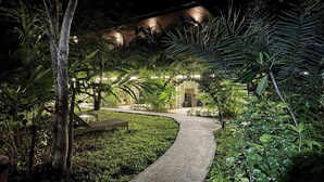 A pathway leading to a building with string lights and lush greenery. - Aonangstudio (Krabi)