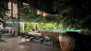 An outdoor pool area with lounge chairs and a large planter. - Aonangstudio (Krabi)