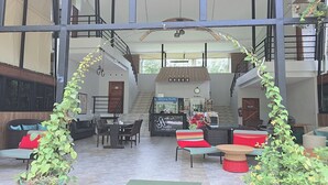 A spacious indoor area with a high ceiling, a staircase, and a coffee station. - Aonangstudio (Krabi)