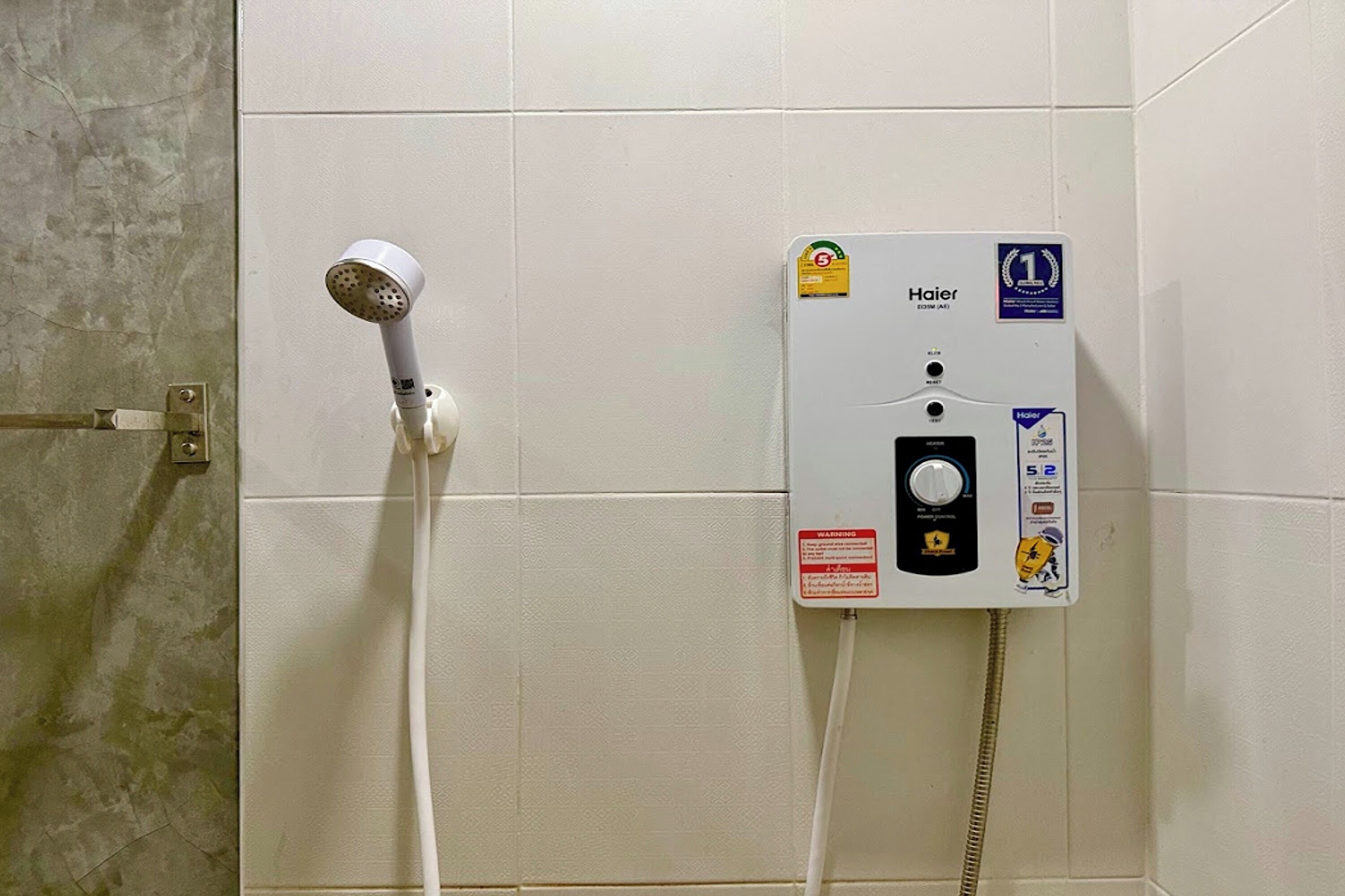 A shower unit with a handheld showerhead and a control panel.