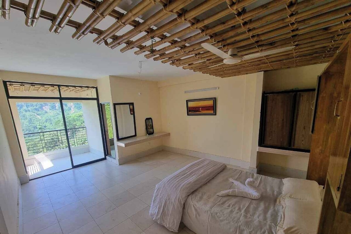 Une chambre à coucher avec un lit, un plafond en bois, une grande fenêtre et une porte.