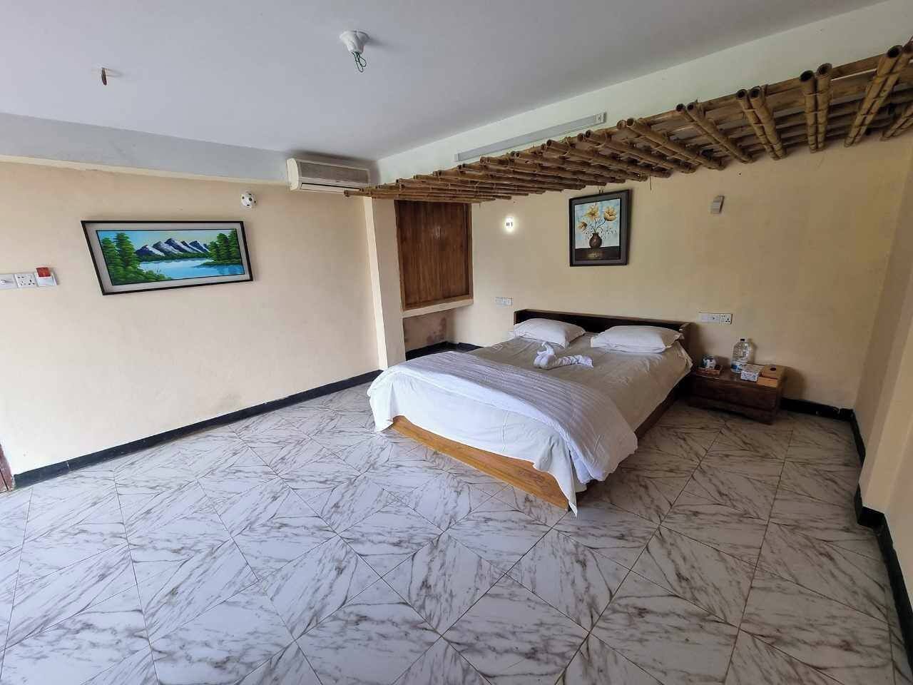 Une chambre d’hôtel avec un lit, une table de chevet et une structure de plafond en bois.