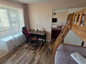 A room with a desk, chair, bed, and a window with curtains. - Cozy&Downtown View (Ulaanbaatar)
