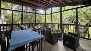 A covered outdoor area with a table, chairs, and a hammock. - Pedasi Craftsman Home, Large Screened Deck, Walk to Town (Los Santos Province)