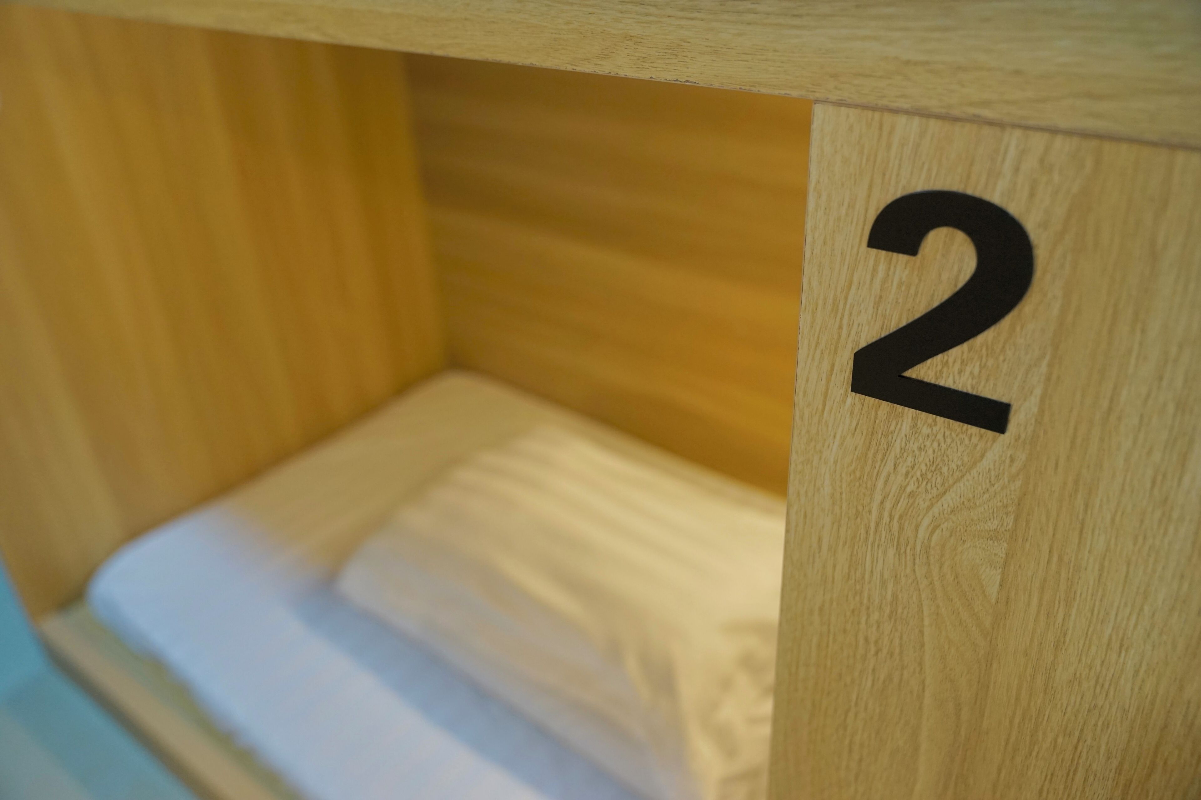 A wooden bed frame with a number '2' indicating room number.