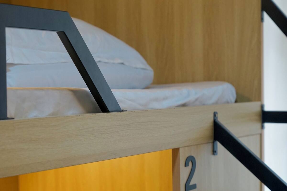 A bunk bed with a wooden frame and a mattress.