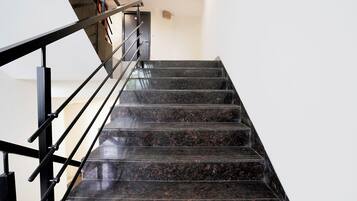 A staircase with black railings and dark granite steps.