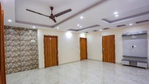 A spacious room with a marble floor, wooden doors, a ceiling fan, and recessed lighting. - Fabhotel Starlight Sanctuary (Gurugram)