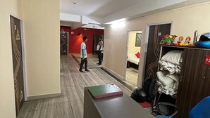 Ein Hotelzimmer mit Holzboden, einem Schreibtisch mit einem Buch, einem Bett und einem Kleiderschrank mit einem roten Schild.