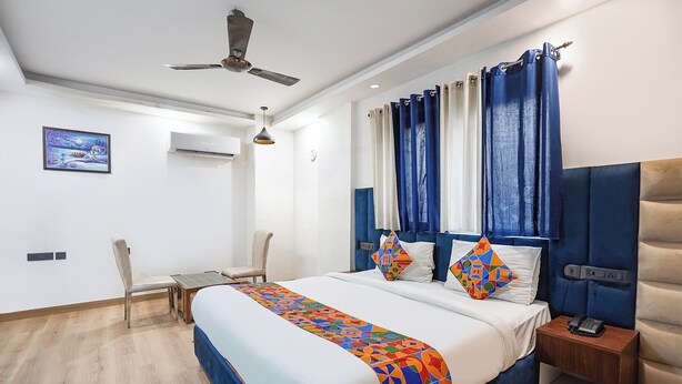 A modern hotel room with a large bed, a desk, and a chair. - Fabhotel Golden Eye Inn (New Delhi)