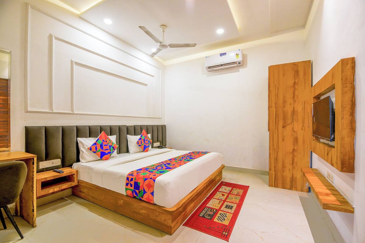 Une chambre à coucher moderne avec un cadre de lit en bois, un téléviseur intégré et un ventilateur de plafond.