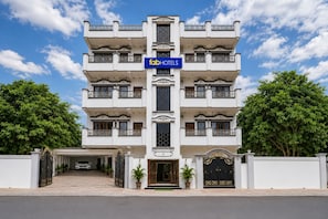 A multi-story hotel with a central entrance, balconies on each floor, and a signboard for 'fabHOTELS'.