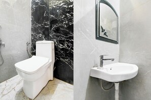A bathroom with a toilet, a sink, and a shower area. - FabHotel RB Palace - Nr. Varanasi Junction (Cantt) Railway Station (Varanasi)