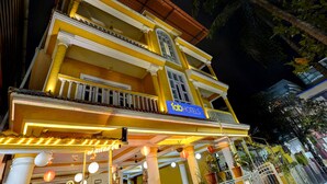 A multi-story building with a prominent 'fab hotels' sign, featuring balconies with railings and potted plants.