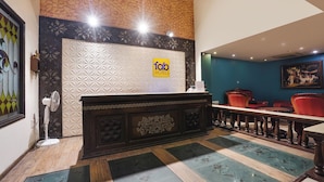 A hotel reception area with a modern design, including a reception desk, seating area, and a decorative wall with a geometric pattern. - Fabhotel Nfc Royale (New Delhi)