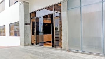 Entrada de hotel con puerta de vidrio y un letrero que dice "V.S. HOTEL (FIRM)".