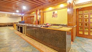 Un'area buffet con un bancone in marmo, travi a vista in legno e pavimento piastrellato.