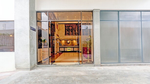Ingresso di un hotel con reception, orologio e insegna 'FAB HOTELS'.