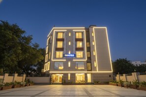 A modern hotel with a flat facade, illuminated windows, and a sign reading "fobHOTELS". - Fabhotel Star Inn (New Delhi)