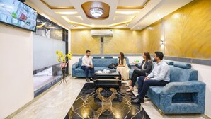 A modern lobby with blue sofas, a marble coffee table, and a large TV screen. - Fabhotel Bkc Annex (Mumbai)