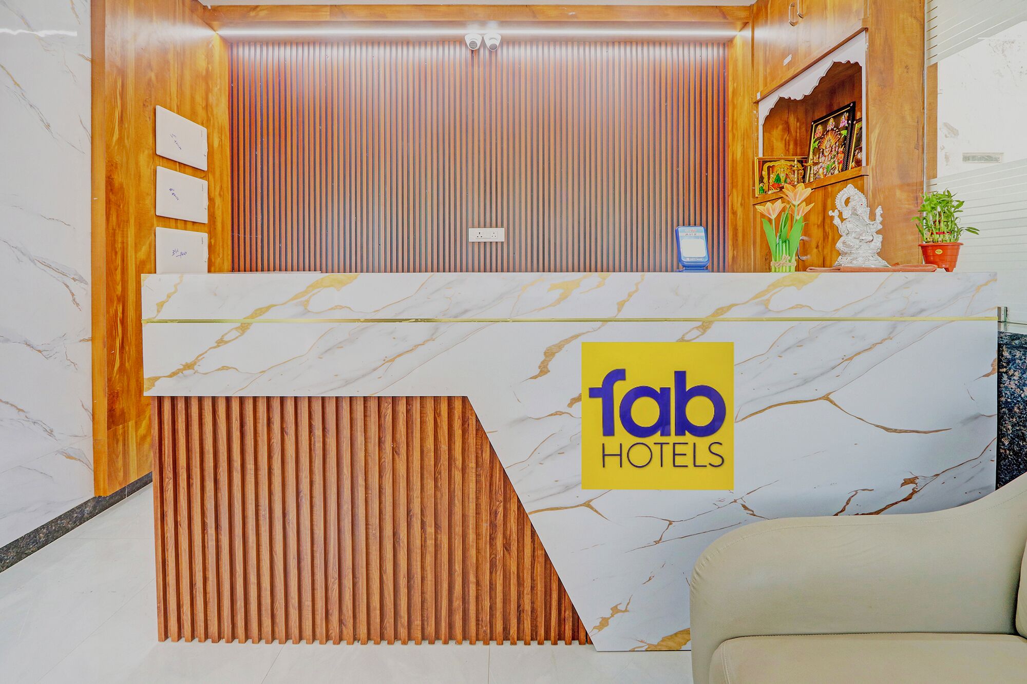 A reception area with a marble counter, a wooden panel wall, and a sign for 'Tab Hotels'.