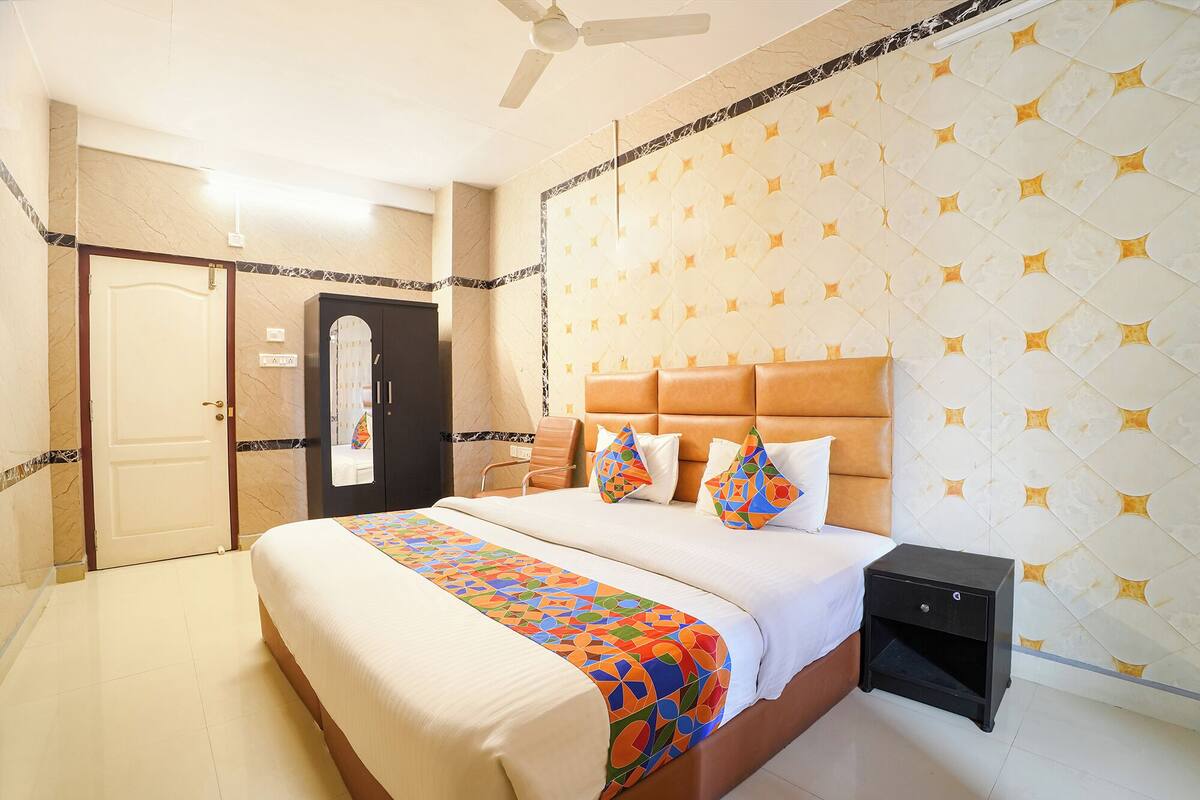 A hotel room with a bed, a nightstand, a wardrobe, and a ceiling fan.