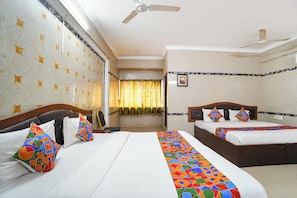 A hotel room with two beds, a ceiling fan, a window with curtains, and a wall with a geometric pattern. - FabHotel Le Royal Inn - Nr Madras Medical Mission Hospital (Chennai)