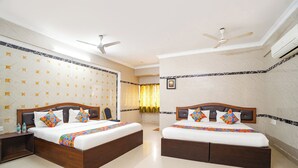 A hotel room with two beds, a ceiling fan, an air conditioning unit, and a patterned wall. - FabHotel Le Royal Inn - Nr Madras Medical Mission Hospital (Chennai)