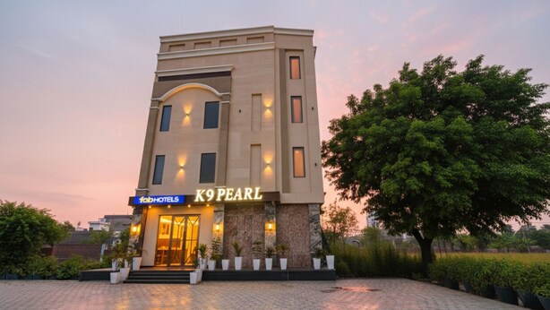 A modern hotel with a prominent entrance, a sign for 'K9 PEARL', and a paved courtyard. - Fabhotel K9 Pearl (Ludhiana)