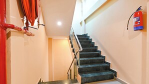 A staircase with a fire extinguisher mounted on the wall. - Fabhotel Sr Grand (Lucknow)