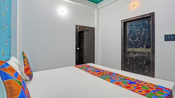 Un dormitorio con cama, puerta y pared con interruptor de luz.