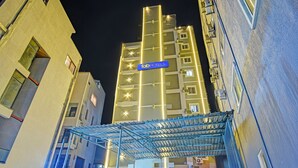 A high-rise building with a blue sign reading "fabHOTELS" at the top. - Fabhotel Dolce Vita Grand (Hyderabad)