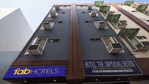 Een meerlaags hotelgebouw met balkons en airconditioners, met een bordje met de tekst 'Fab Hotels'.