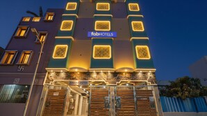 Un edificio de varios pisos con un cartel que dice "fabHOTELS" y una puerta con la leyenda "GARAVINA SHUTTEES".