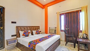 Ein Hotelzimmer mit Bett, Schreibtisch, Stuhl und Klimaanlage.