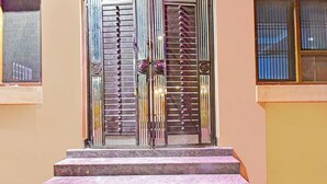 Eine Treppe aus Marmor führt zu einer Doppeltür mit Metallgittern und einem Schlüsselloch.