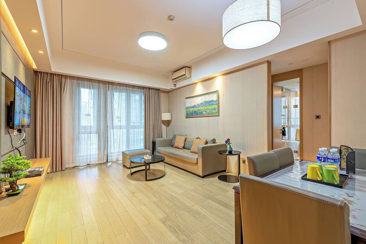 Uma sala de estar moderna com sofá, mesa de centro e área de jantar com mesa e cadeiras.