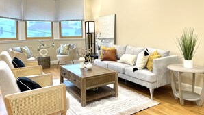 A living room with a sofa, armchairs, a coffee table, and a side table.