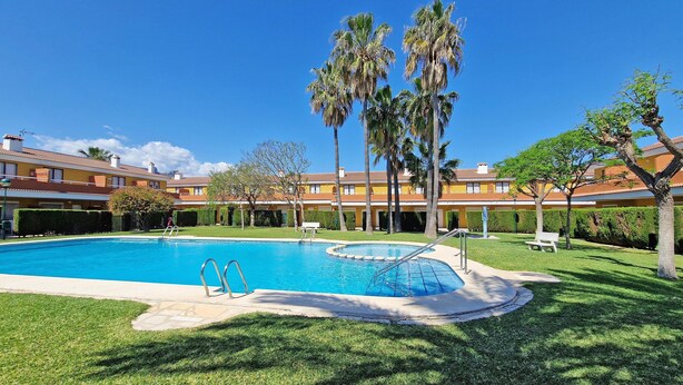 A swimming pool with a circular hot tub, surrounded by well-maintained grass and palm trees. - El Alfar - Denia, Costa Blanca (Denia)