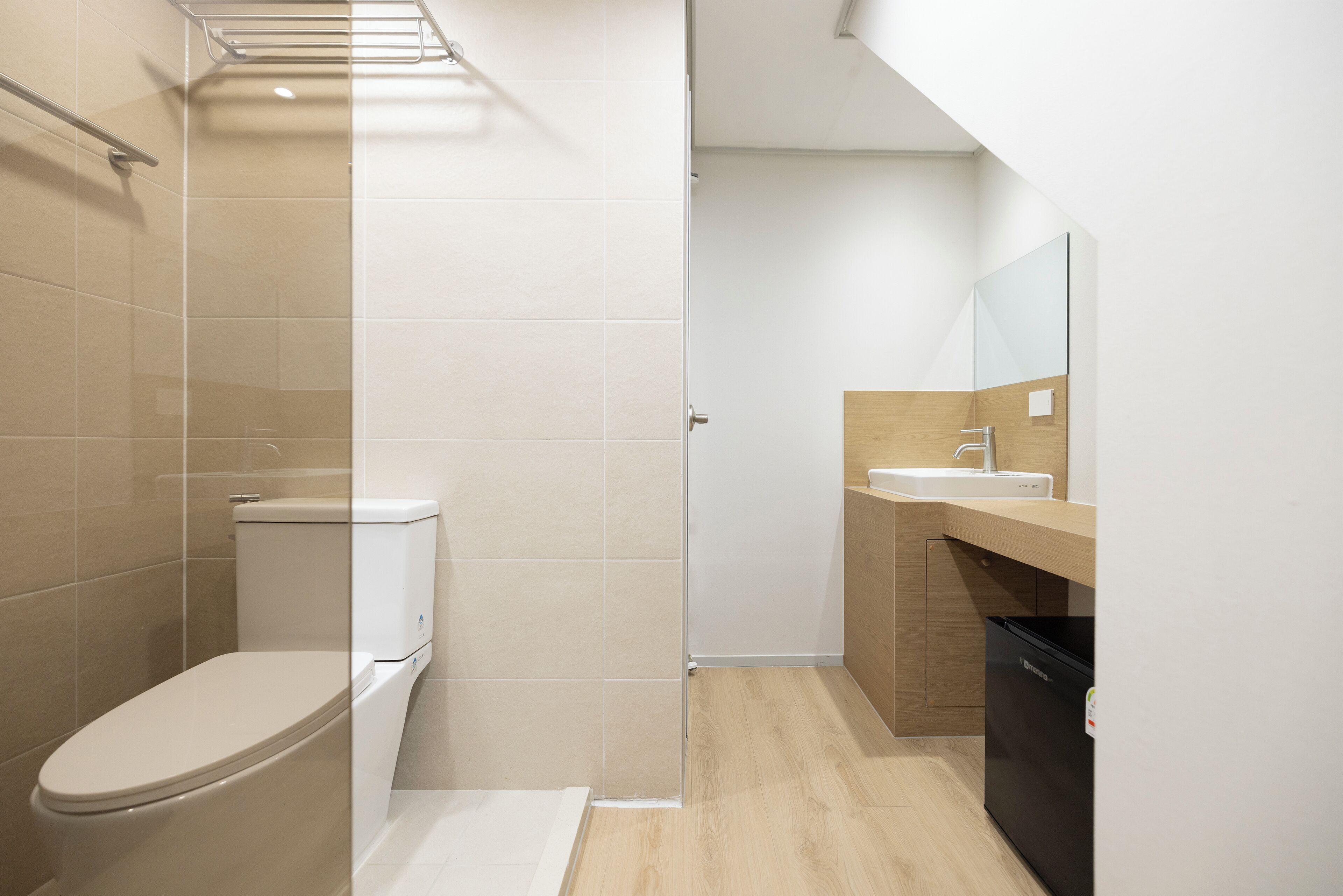 Et moderne badeværelse med toilet, brusebad og vask.