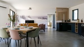 Une cuisine moderne avec un coin repas, un canapé et une vue sur la plage.