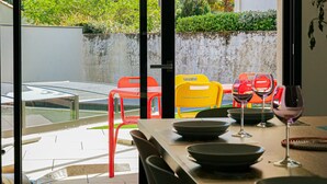 Un espace extérieur aménagé pour prendre les repas, avec vue sur une voiture et sur la verdure.