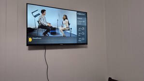Ein Fernseher zeigt eine Nachrichtensendung mit einer Schlagzeile über Kanadas letzte Bemühungen in Washington, D.C., um drohende Zölle abzuwenden.