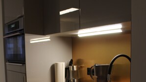 Une cuisine moderne équipée d’un four encastré, d’une machine à café et d  ’une bouilloire.