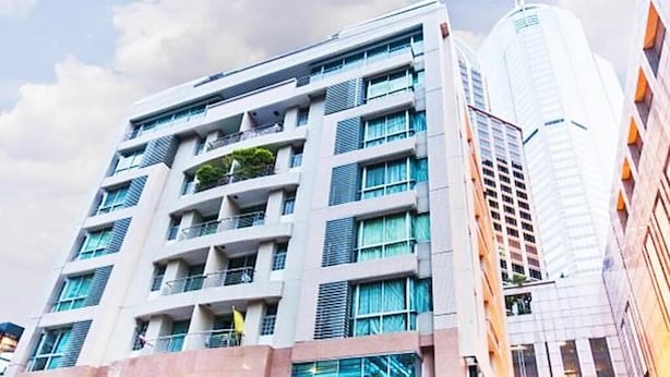 Un hotel de varios pisos con un diseño moderno, que cuenta con balcones y ventanas amplias.