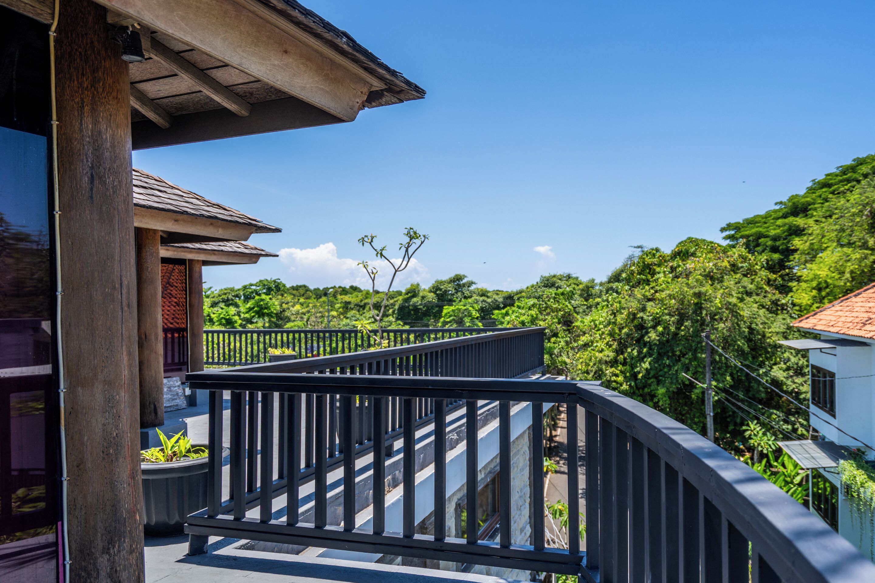 A balcony with a metal railing overlooking a lush green landscape.